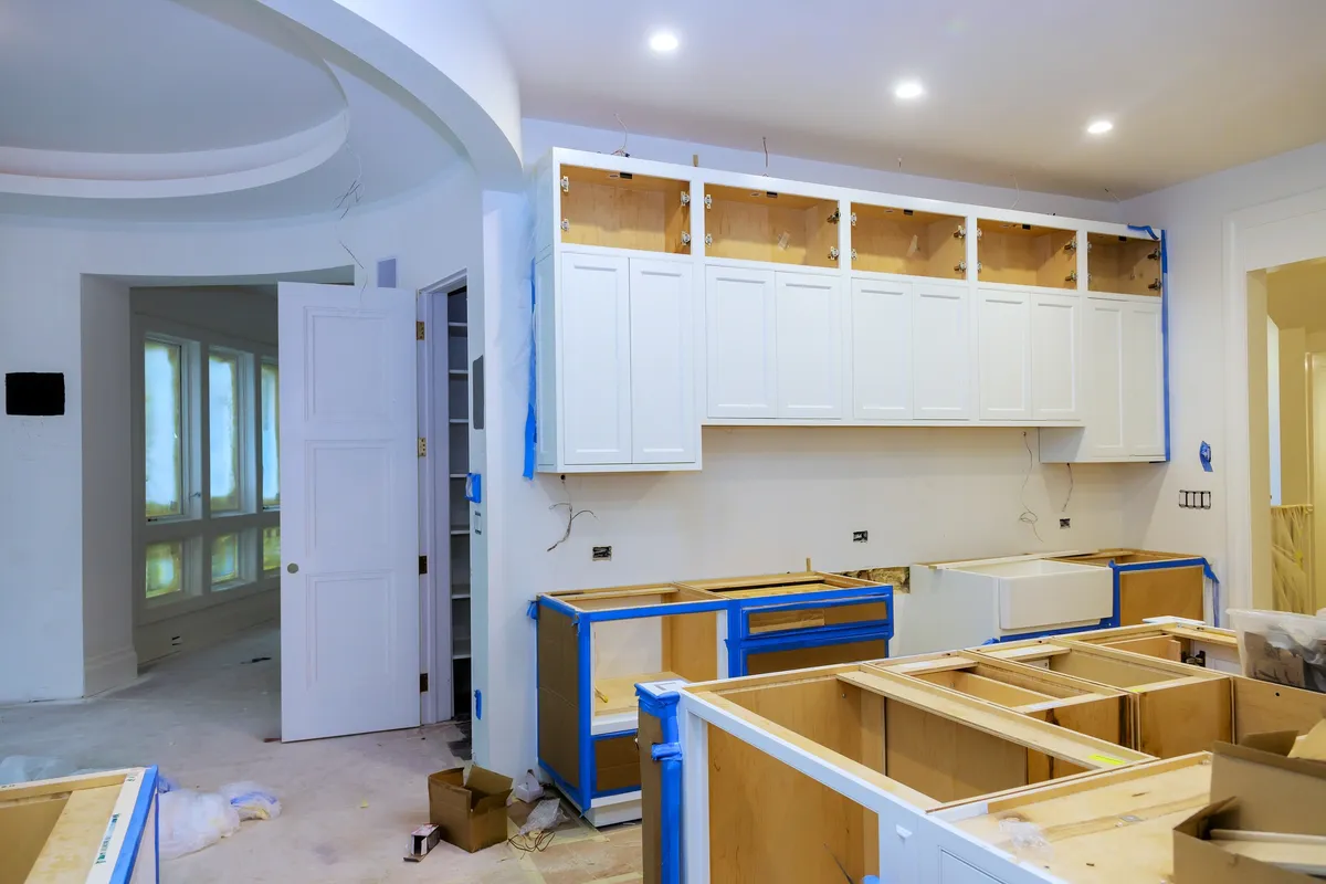 Kitchen mid-project with upper cabinet doors masked and taped